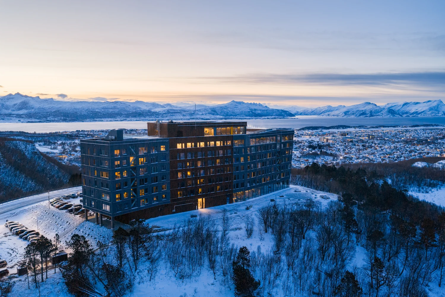Luftfoto av hotell i vinterfjell Hotell i snødekt fjellandskap ved solnedgang fotografert fra luften