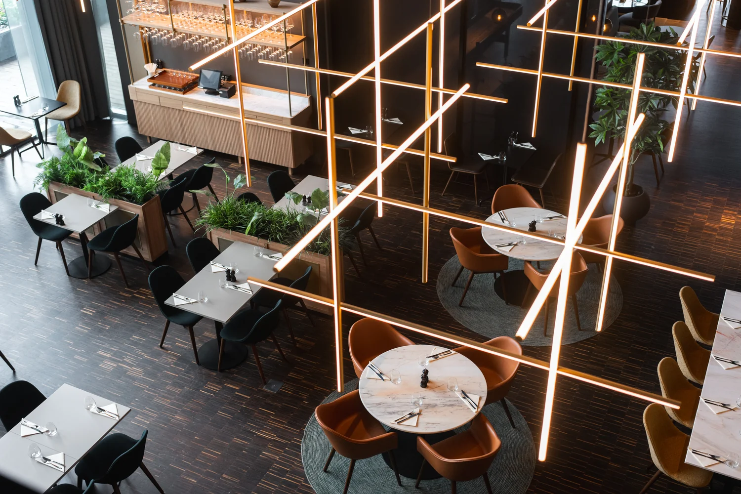 Restaurantområde med gjennomført hotelluttrykk Moderne hotellrestaurant med designbelysning og dekkede bord