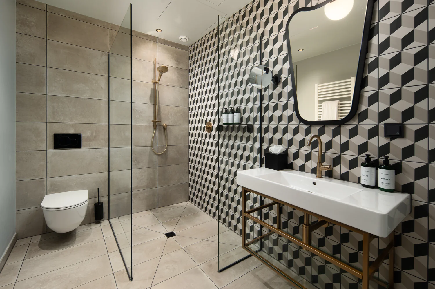 Hotelbad med markant designuttrykk Designorientert hotellbad med dusjnisje, grafiske fliser og kvalitetsarmatur