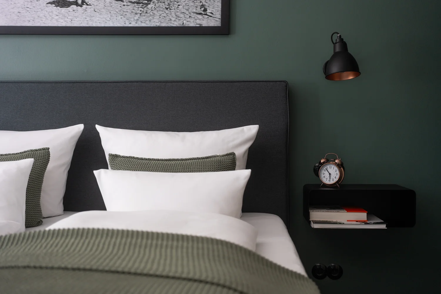 Sengedetaljer i et stilrent hotellrom Detalj fra hotellrom med dobbeltseng, tekstiler og moderne nattbord